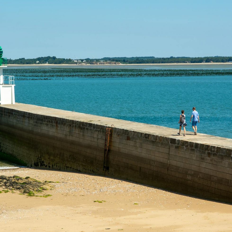 view of people walking toward the mesquer lighthouse pointe de merquel loire atlantique france