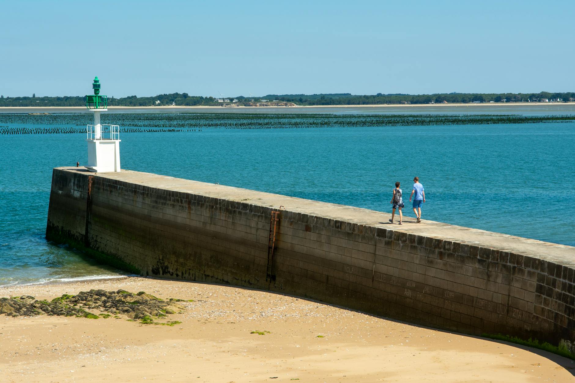 view of people walking toward the mesquer lighthouse pointe de merquel loire atlantique france
